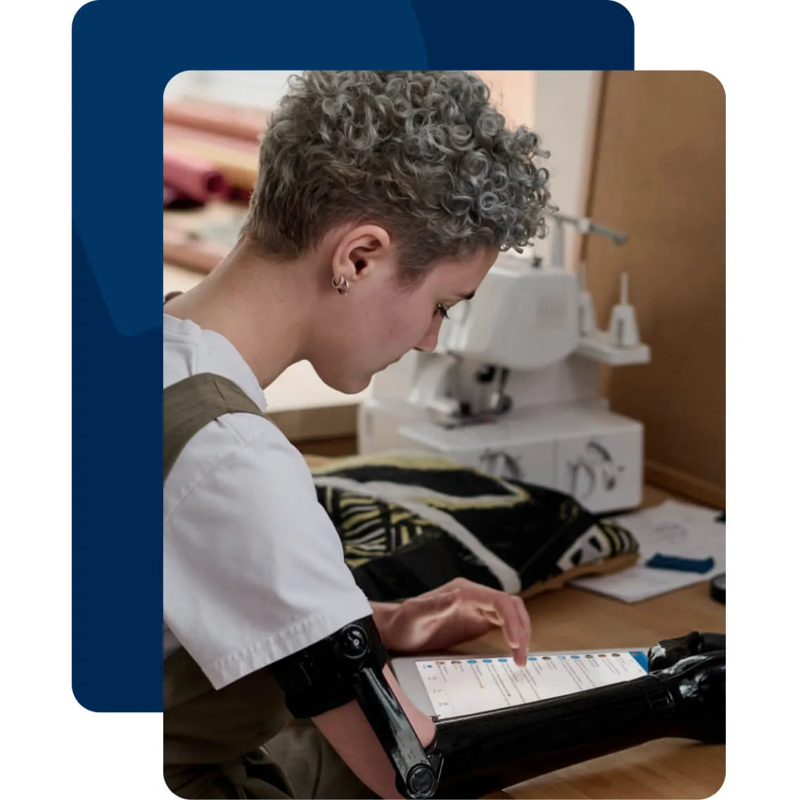 A lady with a prosthetic arm working on a tablet