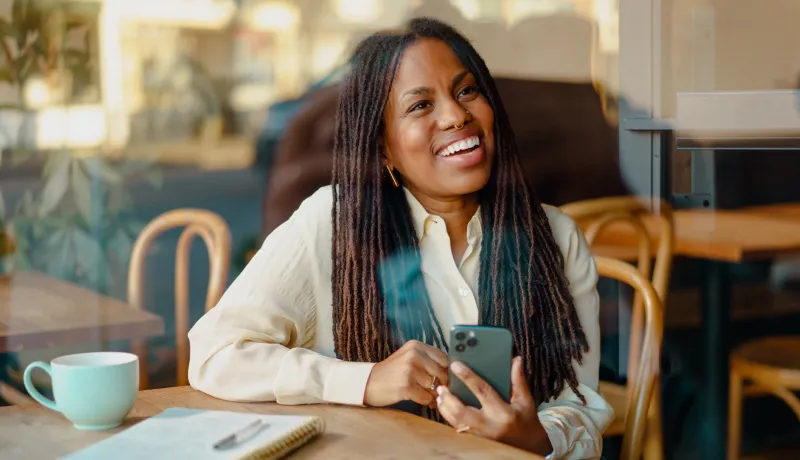 A woman smiling while holding her phone