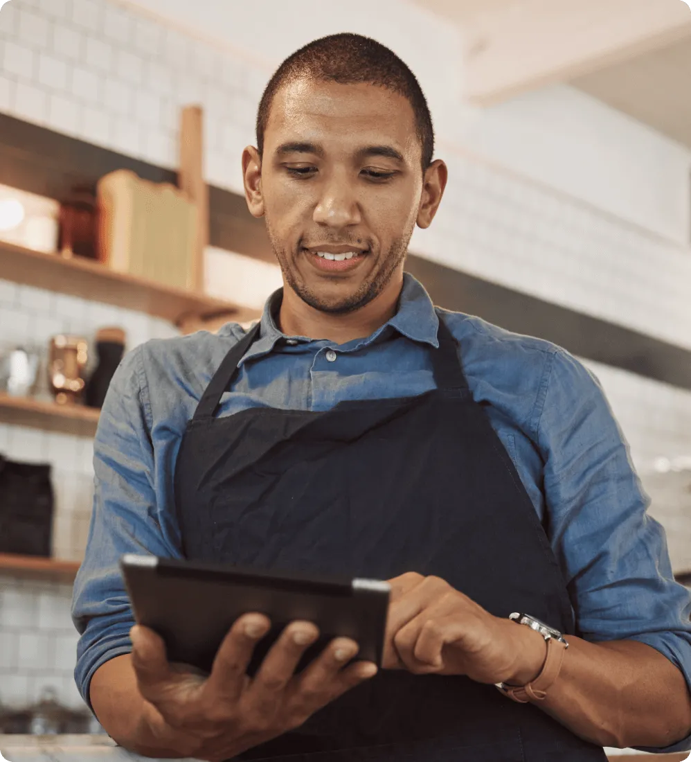 A  male retail store employee taking orders from a tablet by using RingCentral's integrated business communications solution